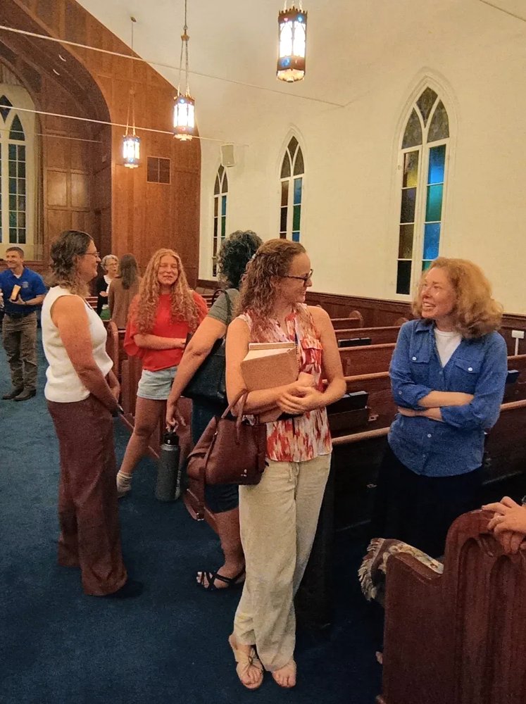 Members of First Baptist Church talking together in the sanctuary